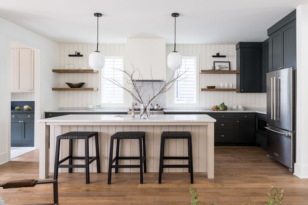 Kitchen - mid-sized transitional l-shaped medium tone wood floor and brown floor kitchen idea in Indianapolis with an undermount sink, shaker cabinets, green cabinets, marble countertops, white backsplash, marble backsplash, stainless steel appliances, an island and white countertops