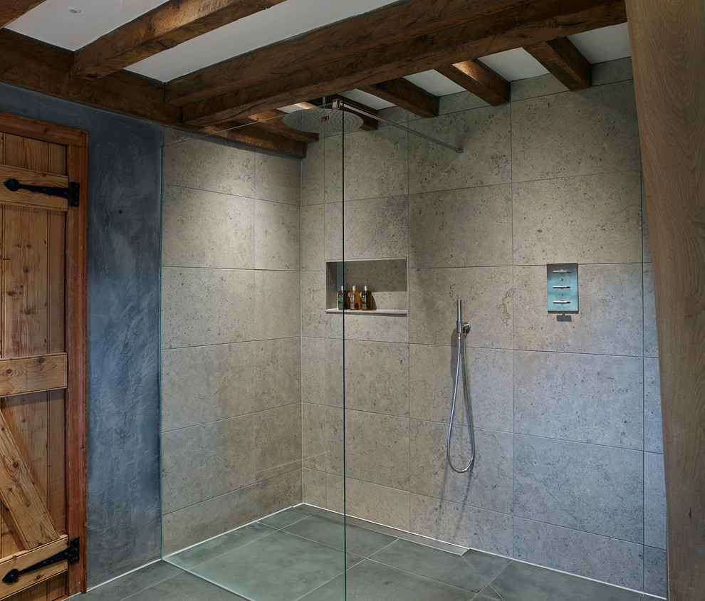 Photo of a mid-sized country kids bathroom in Devon with a console sink, a freestanding tub, a curbless shower, a wall-mount toilet, gray tile, stone tile, grey walls and porcelain floors.