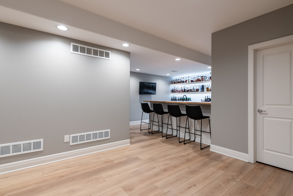 Inspiration pour un sous-sol minimaliste enterré et de taille moyenne avec un bar de salon, un mur gris, un sol en vinyl, un sol beige et différents designs de plafond.