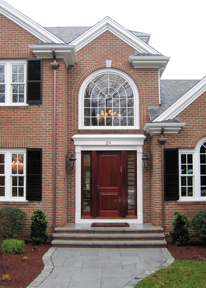 Large traditional three-storey brick house exterior in Boston with a gable roof and a shingle roof.