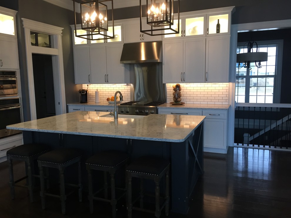 Inspiration for a mid-sized rustic single-wall kitchen remodel with a farmhouse sink, white cabinets, quartz countertops, white appliances and two islands
