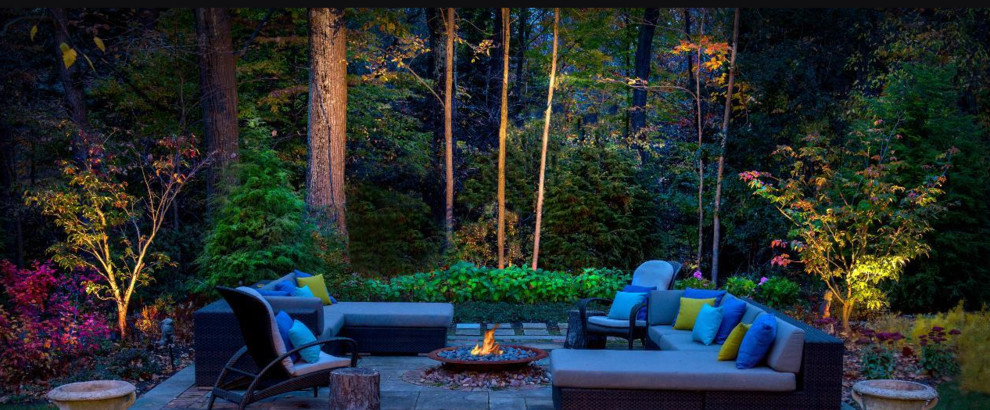 Inspiration for a mid-sized transitional backyard stone patio remodel in Other with a fire pit and no cover