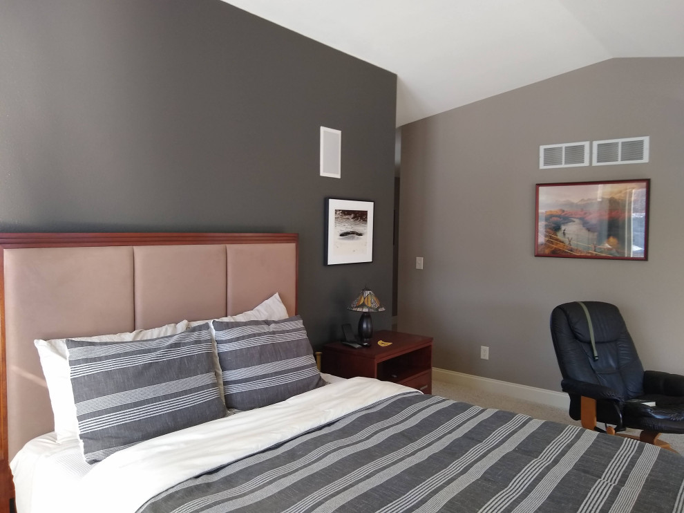 Modelo de dormitorio abovedado de estilo americano de tamaño medio con paredes beige, moqueta y suelo beige