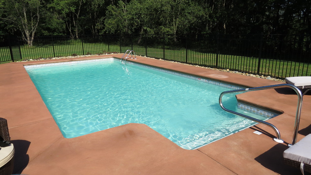 Example of a large minimalist backyard concrete and rectangular pool design