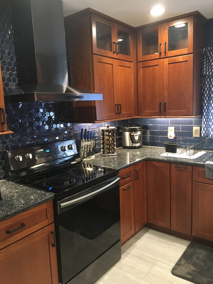 Design ideas for a mid-sized eclectic u-shaped kitchen in Orlando with a single-bowl sink, shaker cabinets, dark wood cabinets, granite benchtops, blue splashback, glass tile splashback, stainless steel appliances, ceramic floors, no island, grey floor and blue benchtop.