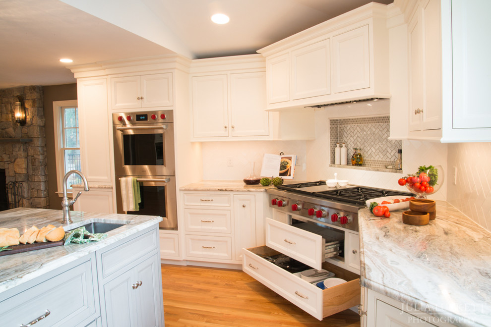 Huge transitional medium tone wood floor eat-in kitchen photo in Boston with a double-bowl sink, recessed-panel cabinets, white cabinets, granite countertops, white backsplash, subway tile backsplash, stainless steel appliances and two islands