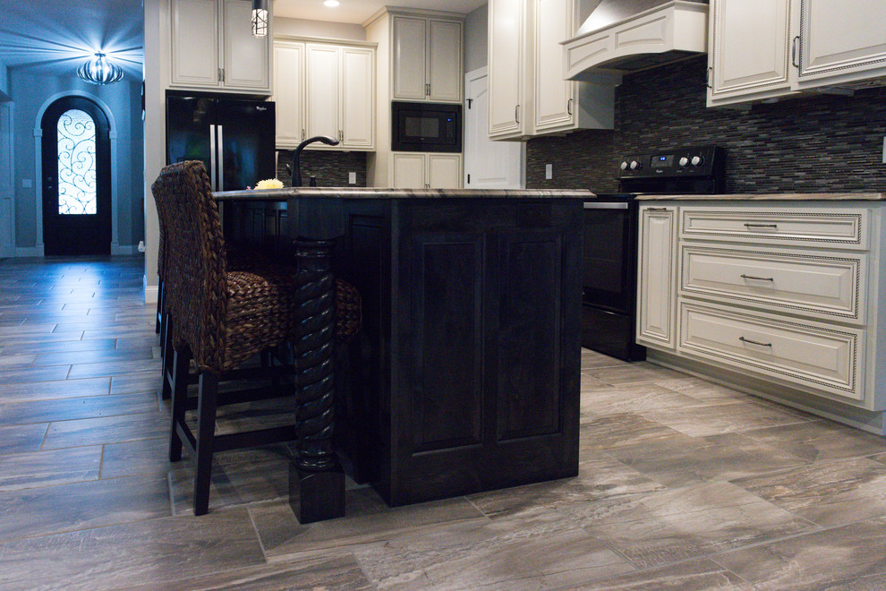 Eat-in kitchen - large transitional l-shaped ceramic tile eat-in kitchen idea in Chicago with an undermount sink, raised-panel cabinets, dark wood cabinets, marble countertops, brown backsplash, glass tile backsplash, black appliances and an island