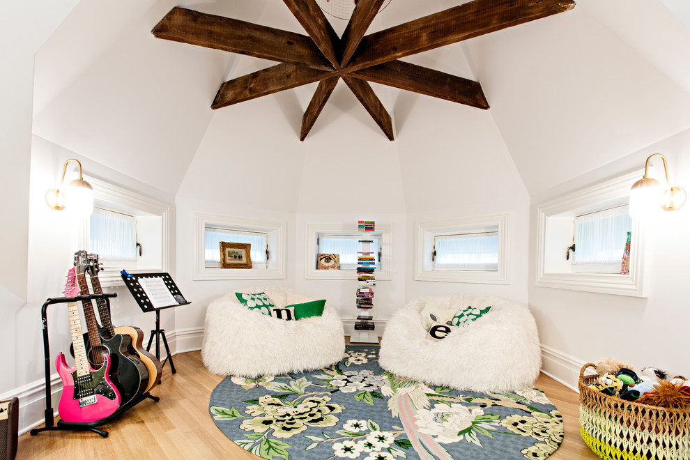 Photo of a large transitional kids' playroom for kids 4-10 years old and girls in New York with white walls, light hardwood floors and beige floor.