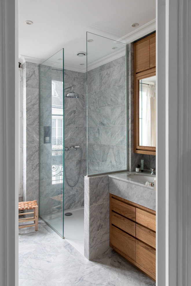 This is an example of a mid-sized contemporary 3/4 bathroom in Paris with flat-panel cabinets, medium wood cabinets, an alcove shower, gray tile, an undermount sink, grey floor, a hinged shower door, grey benchtops, a single vanity and a built-in vanity.
