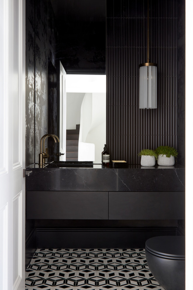 Idéer för mellanstora funkis svart toaletter, med släta luckor, svarta skåp, en vägghängd toalettstol, svart kakel, marmorkakel, svarta väggar, klinkergolv i keramik, ett nedsänkt handfat, marmorbänkskiva och svart golv