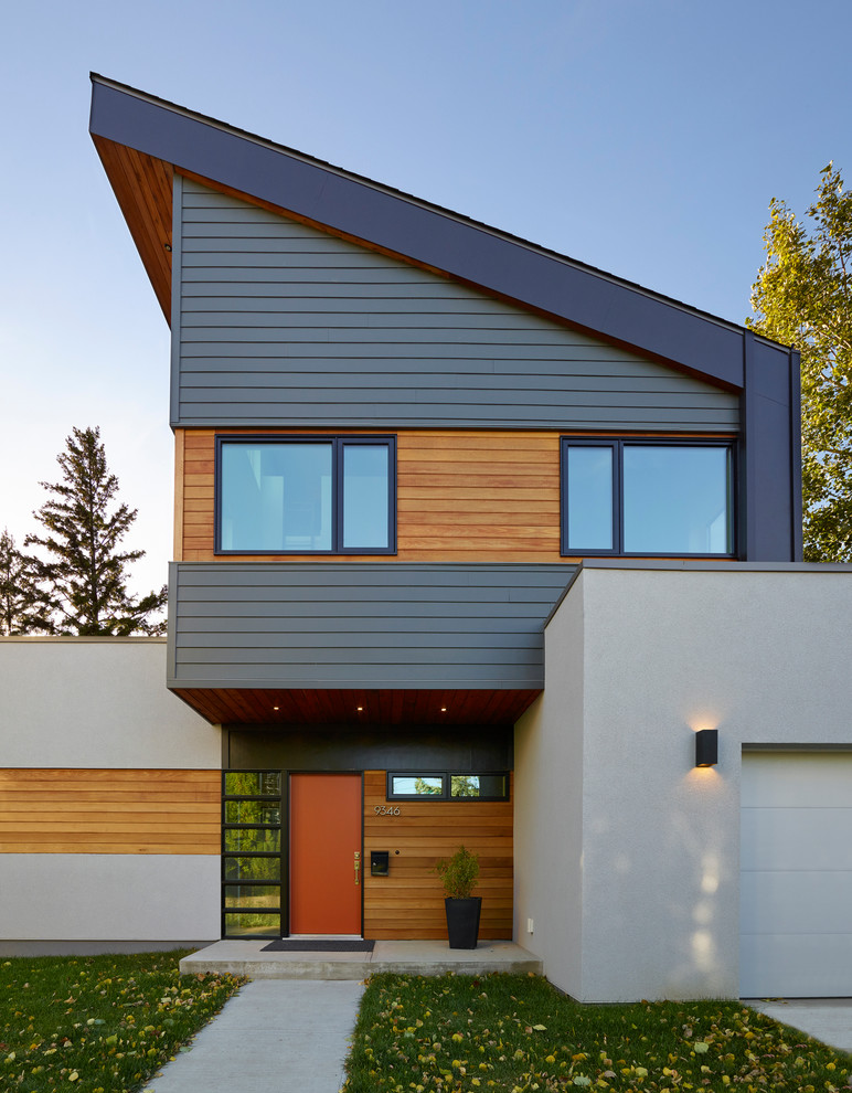 Photo of a large modern two-storey white house exterior in Edmonton with a shed roof and mixed siding.