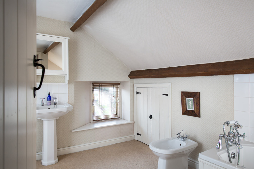 Photo of a mid-sized country 3/4 bathroom in Other with a pedestal sink, white cabinets, an alcove tub, white tile, ceramic tile and beige walls.