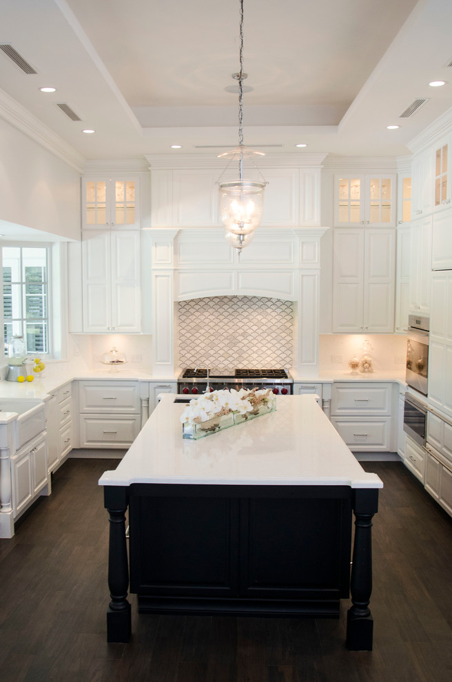 This is an example of a large transitional u-shaped separate kitchen in Miami with a farmhouse sink, raised-panel cabinets, white cabinets, quartz benchtops, grey splashback, porcelain splashback, panelled appliances and with island.