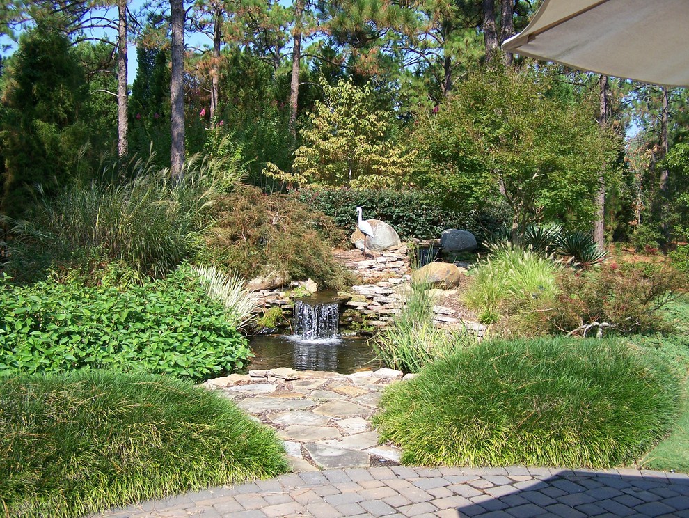This is an example of a traditional garden in Raleigh with a water feature.