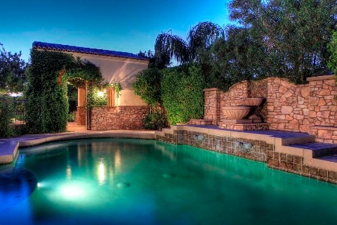 Pool fountain - large mediterranean backyard stone and custom-shaped pool fountain idea in Phoenix