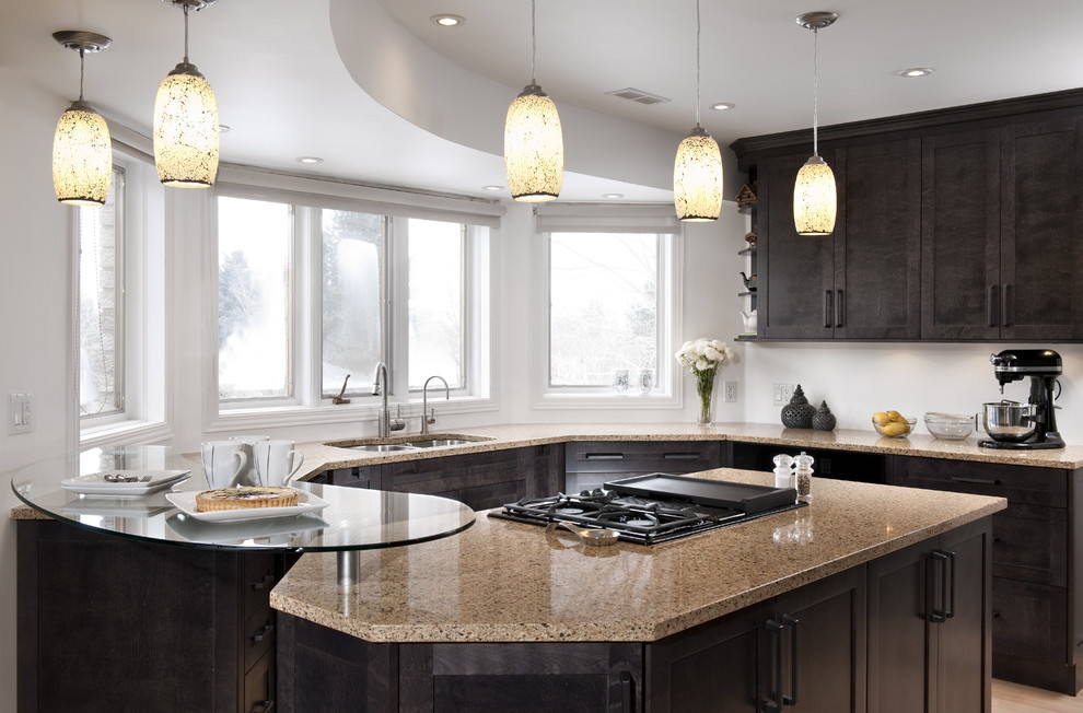 Inspiration for a mid-sized transitional u-shaped light wood floor eat-in kitchen remodel with shaker cabinets, dark wood cabinets, quartz countertops, black appliances, a peninsula and beige countertops