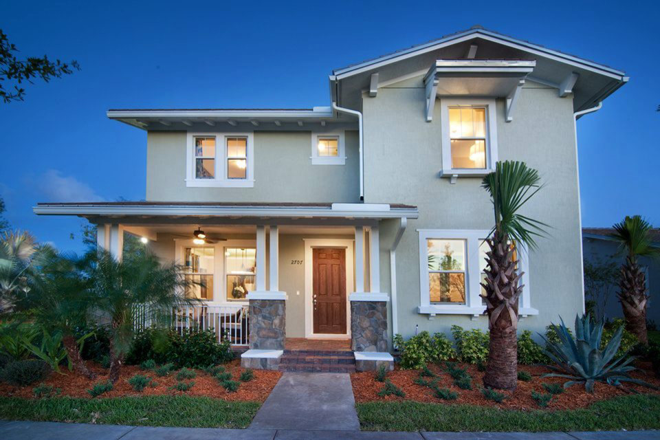 This is an example of a mid-sized tropical two-storey beige exterior in Tampa with mixed siding.
