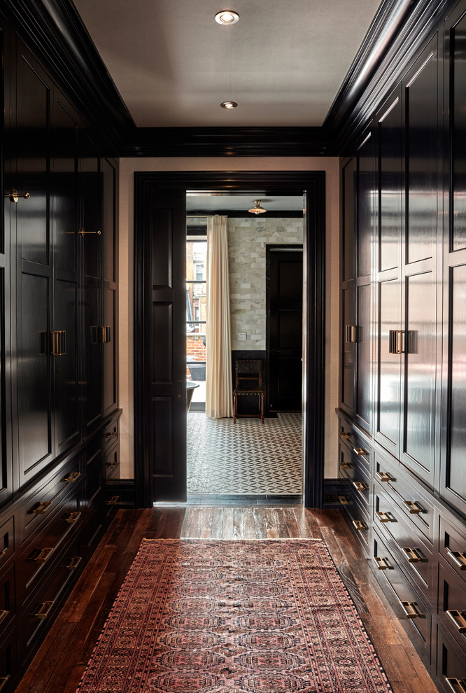 This is an example of a mid-sized traditional gender-neutral walk-in wardrobe in Philadelphia with shaker cabinets, dark wood cabinets and dark hardwood floors.