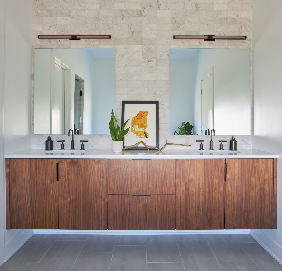 This is an example of a midcentury master bathroom in Chicago with flat-panel cabinets, medium wood cabinets, a freestanding tub, a double shower, black and white tile, marble, ceramic floors, an undermount sink, engineered quartz benchtops, grey floor, a hinged shower door, white benchtops, an enclosed toilet, a double vanity and a floating vanity.