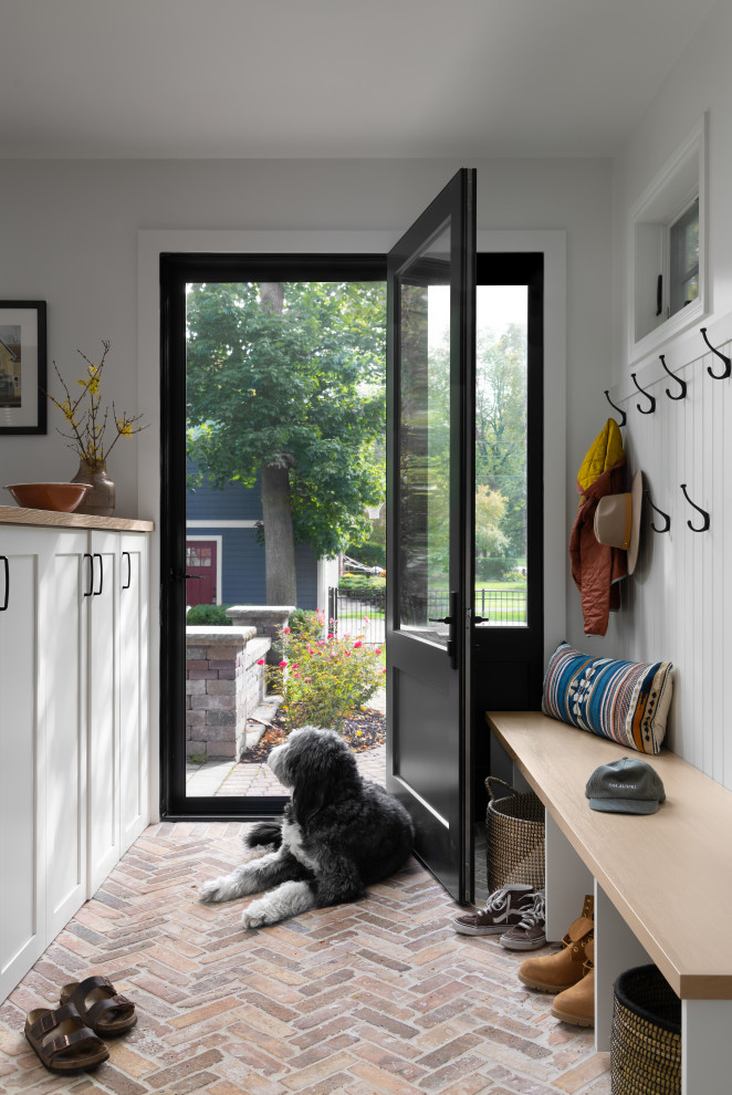 Источник вдохновения для домашнего уюта: тамбур среднего размера в стиле модернизм с бежевыми стенами, кирпичным полом, одностворчатой входной дверью, черной входной дверью и бежевым полом