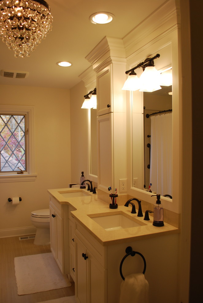 Photo of a small traditional kids bathroom in Cleveland with recessed-panel cabinets, white cabinets, an alcove tub, a shower/bathtub combo, beige tile, ceramic tile, beige walls, porcelain floors, an undermount sink and engineered quartz benchtops.