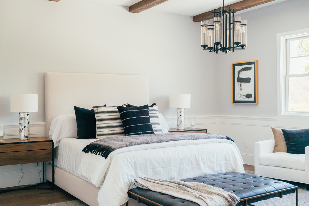 Beach style bedroom in Los Angeles with grey walls, medium hardwood floors and brown floor.