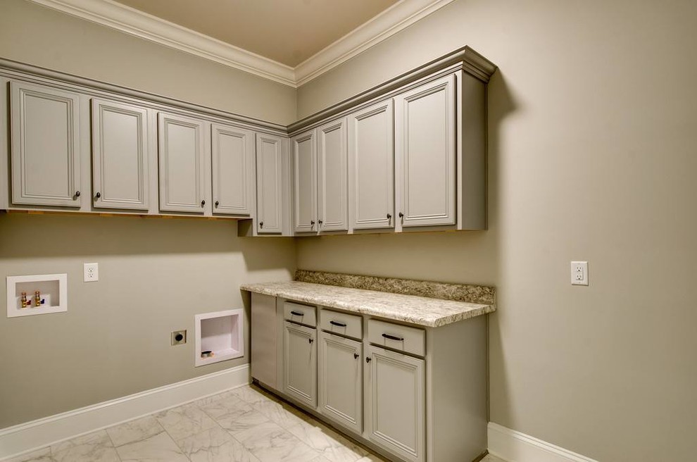 Example of a mid-sized transitional l-shaped marble floor and white floor dedicated laundry room design with recessed-panel cabinets, beige cabinets, laminate countertops, beige walls and a side-by-side washer/dryer