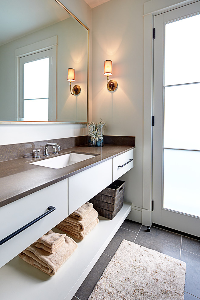 This is an example of a large modern 3/4 bathroom in Austin with an undermount sink, flat-panel cabinets, white cabinets, engineered quartz benchtops, an open shower, a one-piece toilet, gray tile, stone tile, white walls and limestone floors.