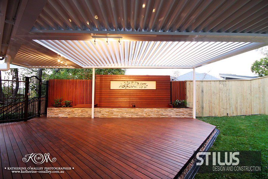 This is an example of a mid-sized modern backyard deck in Sunshine Coast with a pergola.