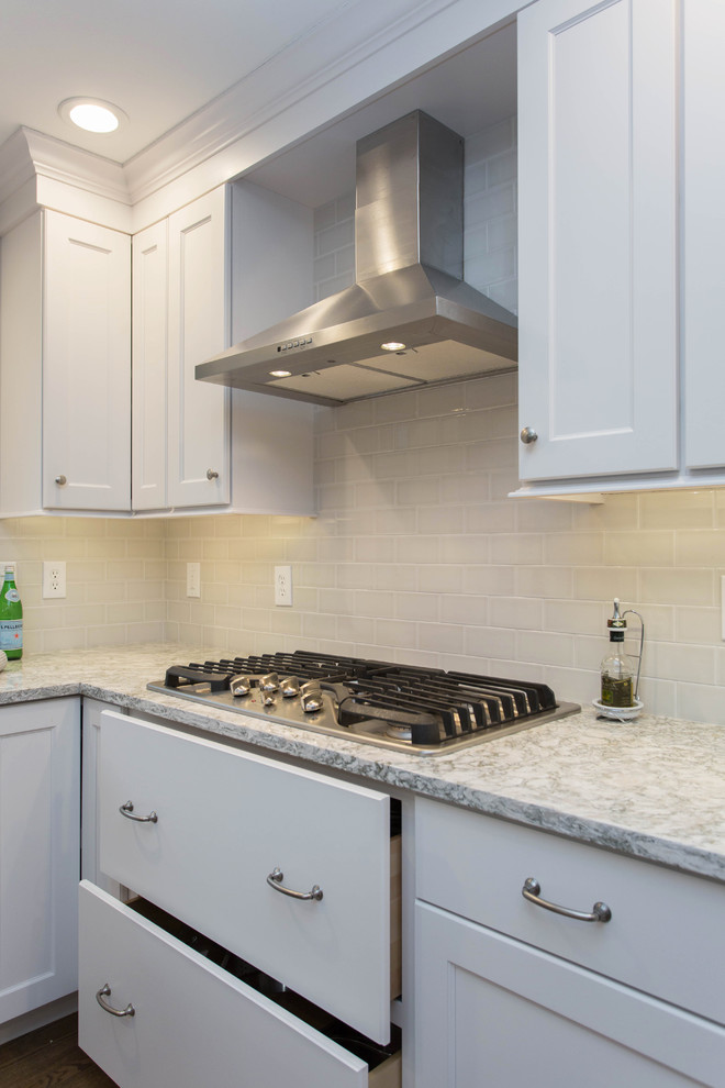 Inspiration for a mid-sized transitional u-shaped dark wood floor enclosed kitchen remodel in Boston with an undermount sink, recessed-panel cabinets, white cabinets, quartz countertops, gray backsplash, subway tile backsplash, stainless steel appliances and an island