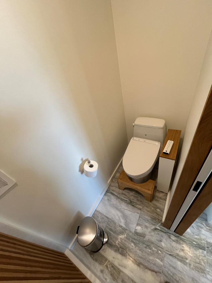 Cette image montre une grande douche en alcôve principale minimaliste en bois brun avec un placard à porte plane, une baignoire encastrée, WC à poser, un carrelage blanc, des carreaux en terre cuite, un mur blanc, tomettes au sol, un lavabo encastré, un plan de toilette en granite, un sol beige, une cabine de douche à porte battante, un plan de toilette noir, une niche, meuble simple vasque et meuble-lavabo encastré.