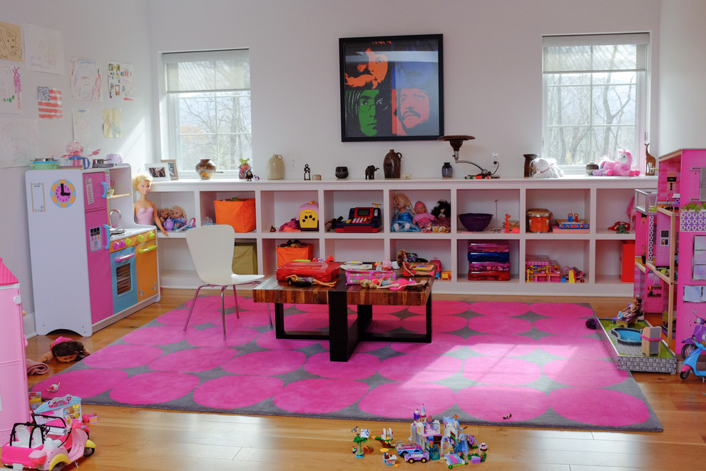 Photo of a small eclectic kids' playroom for kids 4-10 years old and girls in Other with white walls, light hardwood floors and beige floor.