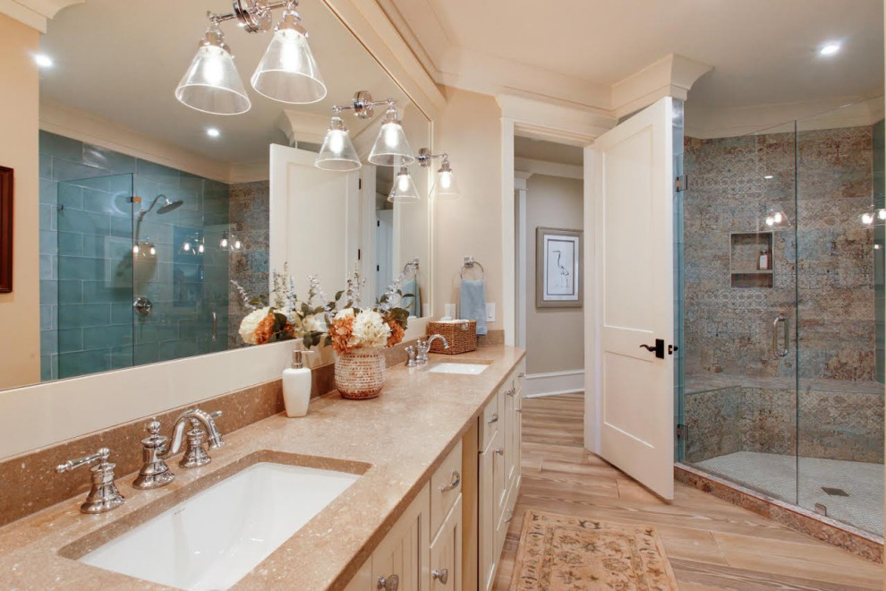 Photo of a country bathroom in Atlanta with recessed-panel cabinets, beige cabinets, a corner shower, multi-coloured tile, ceramic tile, beige walls, an undermount sink, a hinged shower door and orange benchtops.