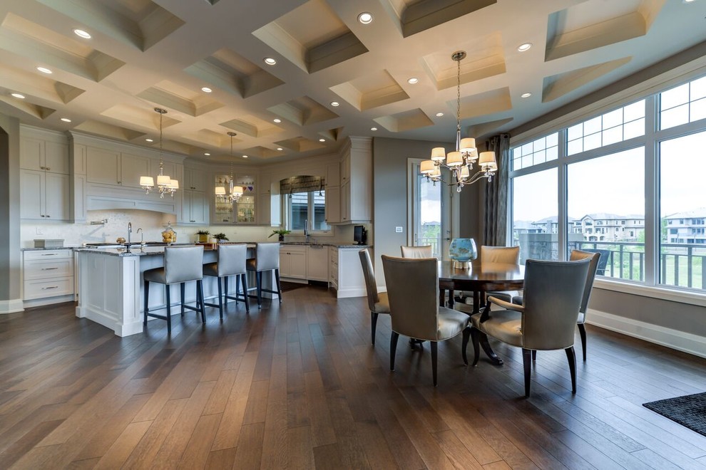 Example of a large transitional u-shaped medium tone wood floor and brown floor kitchen design in Edmonton with shaker cabinets, white cabinets, granite countertops, white backsplash, an island, an undermount sink, glass tile backsplash and paneled appliances