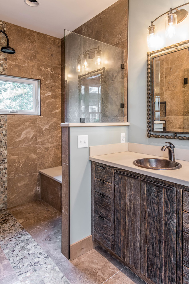 Large mountain style master brown tile and stone slab brown floor drop-in bathtub photo with flat-panel cabinets, dark wood cabinets, gray walls, a drop-in sink, solid surface countertops, a hinged shower door and gray countertops