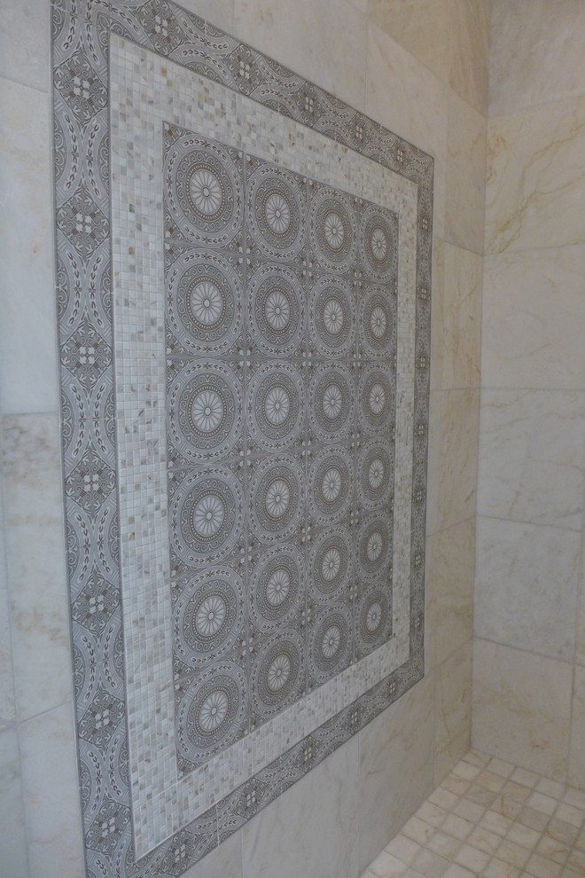 This is an example of a transitional master bathroom in Houston with stone tile and marble floors.