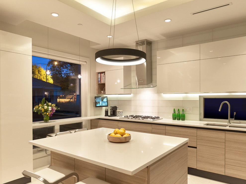 Photo of a contemporary u-shaped kitchen in Vancouver with an undermount sink, flat-panel cabinets, quartz benchtops, white splashback, glass tile splashback, panelled appliances, ceramic floors and with island.