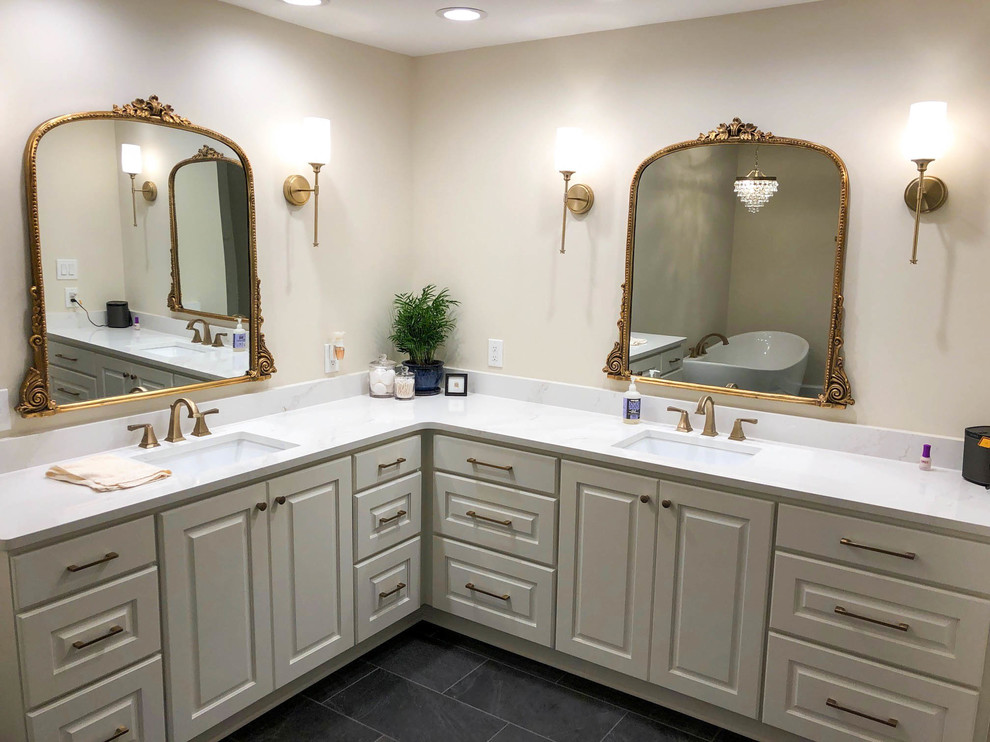 Photo of a large transitional master bathroom in Other with raised-panel cabinets, white cabinets, a freestanding tub, a curbless shower, white tile, ceramic tile, slate floors, an undermount sink, engineered quartz benchtops, grey floor, a hinged shower door and white benchtops.