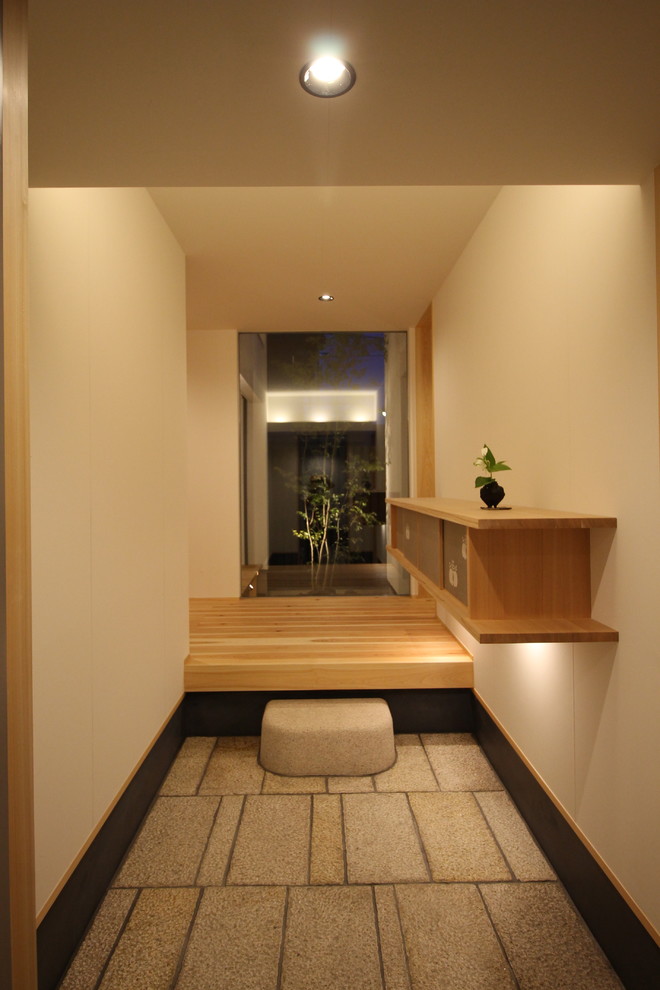 Inspiration for a contemporary entryway in Kyoto with white walls and beige floor.