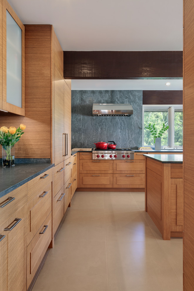 This is an example of a large contemporary u-shaped eat-in kitchen in Bridgeport with an undermount sink, raised-panel cabinets, medium wood cabinets, limestone benchtops, grey splashback, stone slab splashback, panelled appliances, porcelain floors, with island and beige floor.