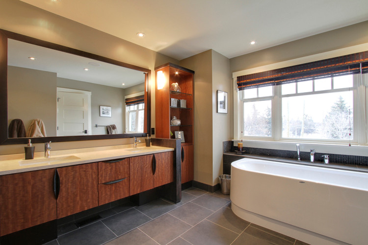 Inspiration for an expansive contemporary master bathroom in Calgary with an undermount sink, flat-panel cabinets, medium wood cabinets, engineered quartz benchtops, a freestanding tub, a corner shower, a two-piece toilet, beige walls and ceramic floors.