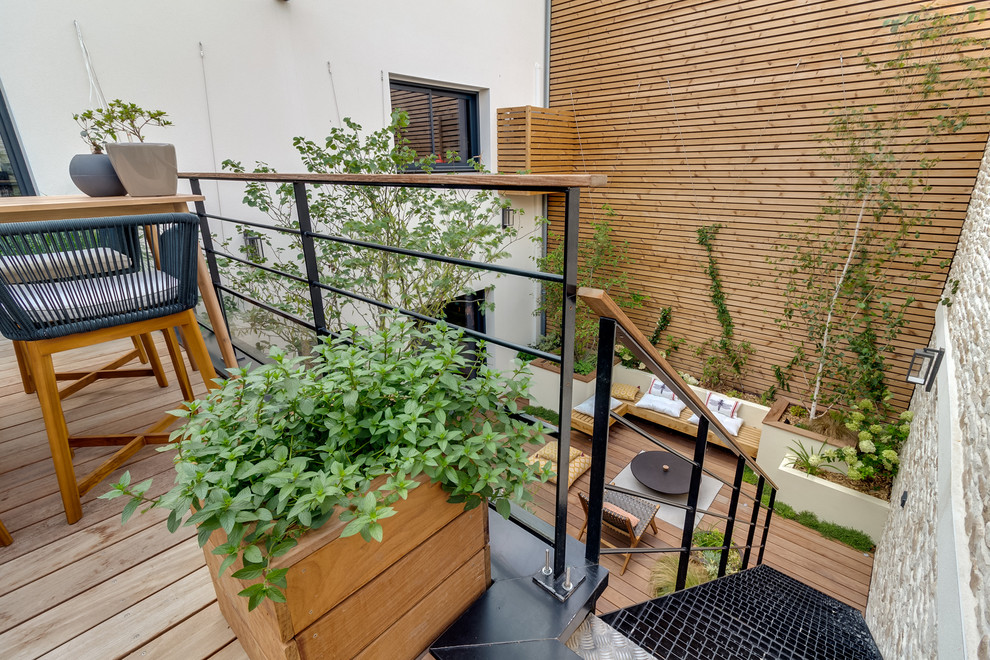 Large contemporary courtyard patio in Nantes with an outdoor kitchen, decking and a roof extension.