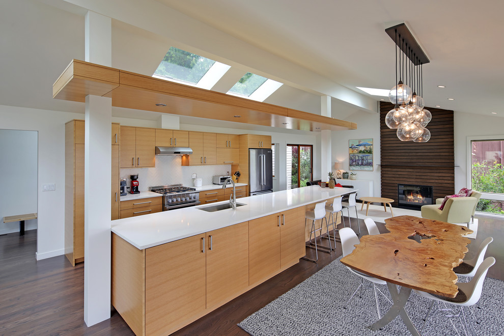 Inspiration for a contemporary galley open plan kitchen in Seattle with an undermount sink, flat-panel cabinets, light wood cabinets, white splashback, stainless steel appliances, dark hardwood floors and with island.