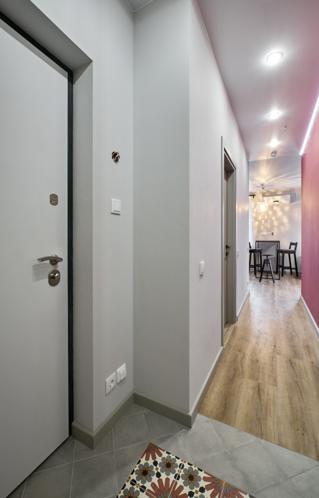 Ispirazione per un piccolo corridoio classico con pareti grigie, pavimento con piastrelle in ceramica, una porta blu, pavimento multicolore e boiserie