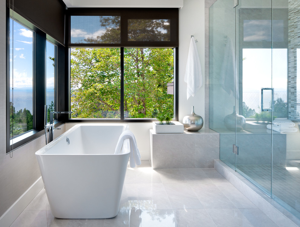 Contemporary bathroom in Vancouver with a freestanding tub, an alcove shower and gray tile.