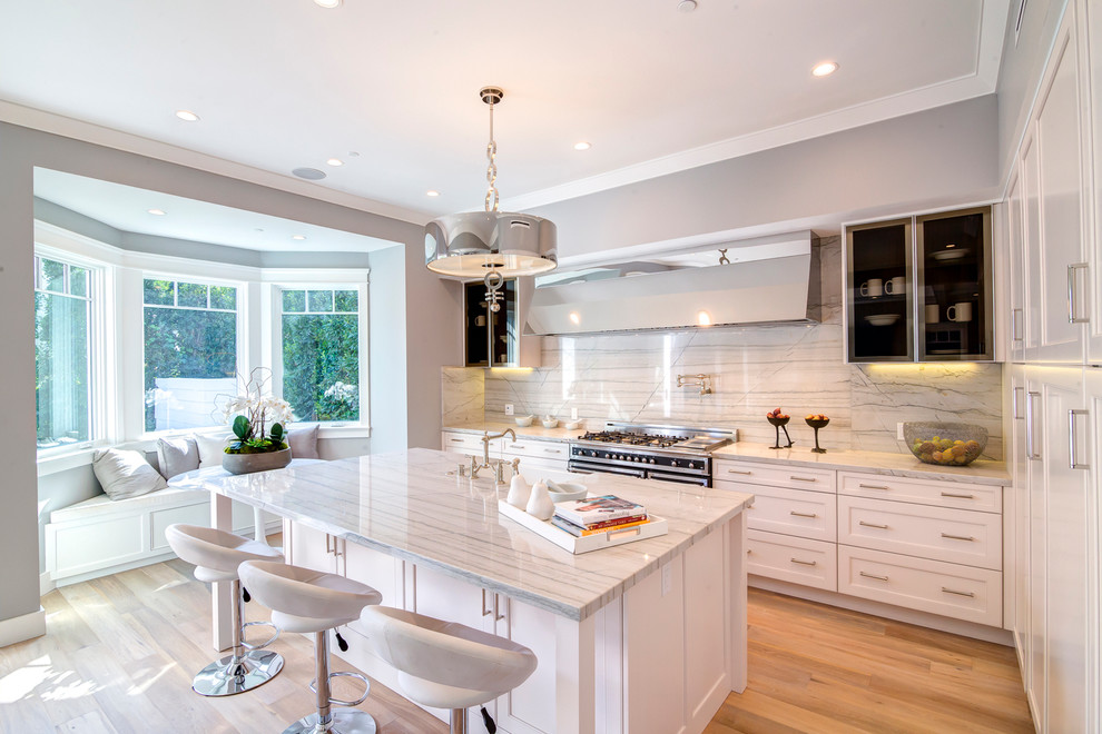 Photo of a transitional kitchen in Los Angeles with shaker cabinets, white cabinets, multi-coloured splashback, light hardwood floors and with island.