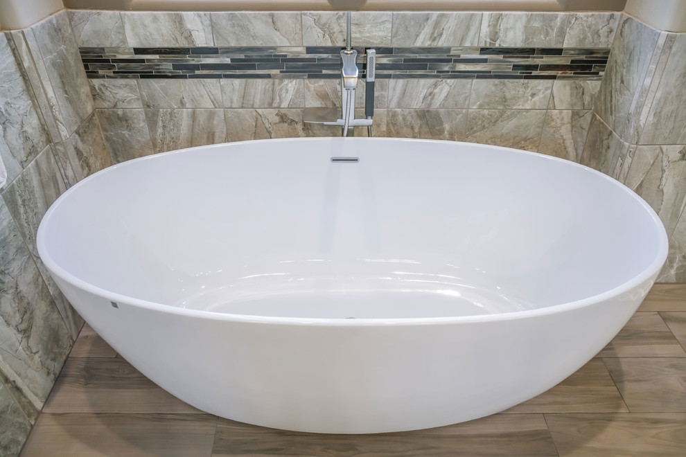 Inspiration for a mid-sized transitional master brown tile porcelain tile freestanding bathtub remodel in Phoenix with recessed-panel cabinets, brown cabinets, beige walls, an undermount sink and quartz countertops