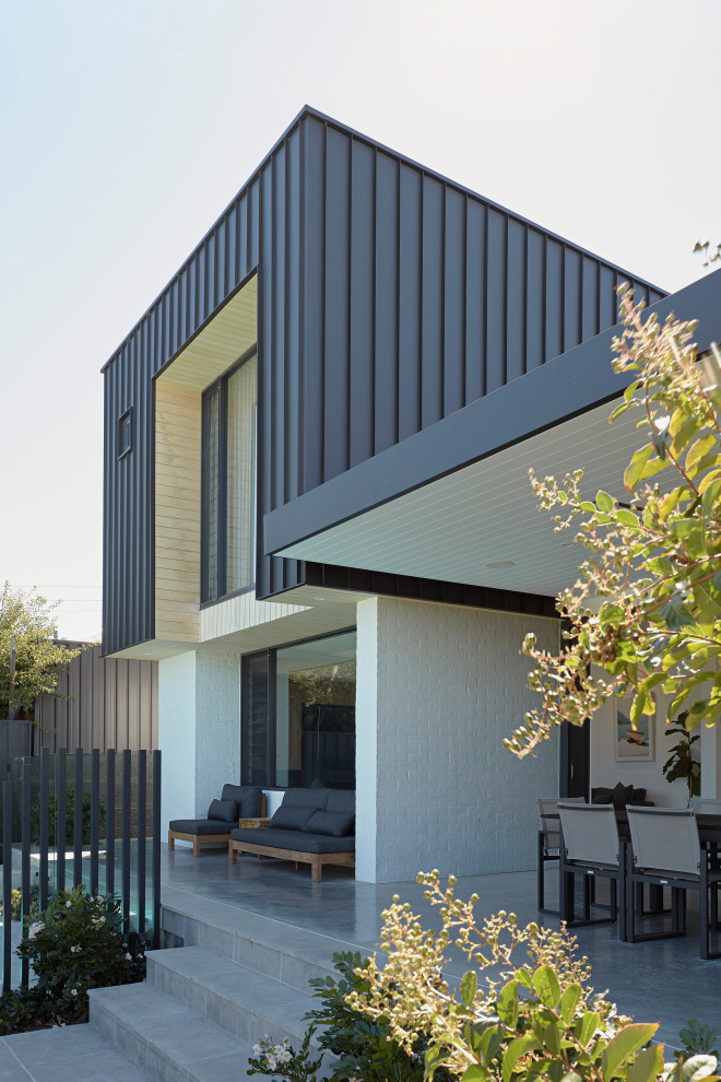 Идея дизайна: разноцветный частный загородный дом в стиле модернизм с односкатной крышей, металлической крышей, черной крышей и разными уровнями