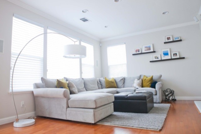 This is an example of a mid-sized contemporary open concept family room in San Francisco with white walls, medium hardwood floors and a wall-mounted tv.