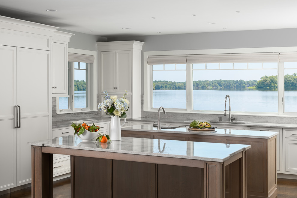Large transitional u-shaped kitchen in Boston with an undermount sink, flat-panel cabinets, white cabinets, quartzite benchtops, panelled appliances, dark hardwood floors, multiple islands and brown floor.